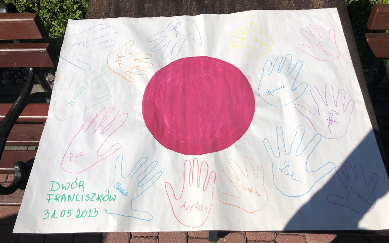 Photo of A Japanese flag, with hands and names drawn on it, was presented to the team from the children as a show of appreciation when they visited the refugee facility.