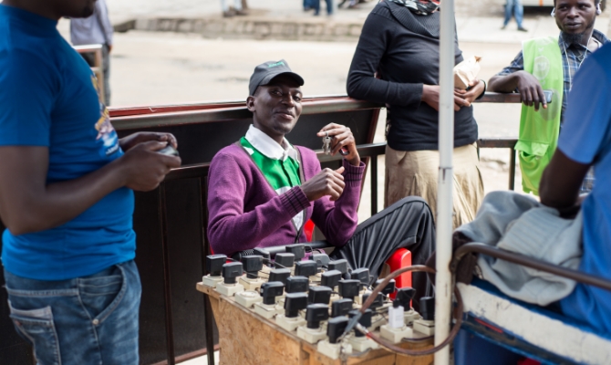 Photo of Amid underdevelopment of the power grid and landline systems, smartphone charging services are flourishing on the streets. Smartphones have spread rapidly, and are dominating financial transactions. The current African economy is mirrored in everyday scenes like this. (Photo taken near Lake Kivu in Rwanda)