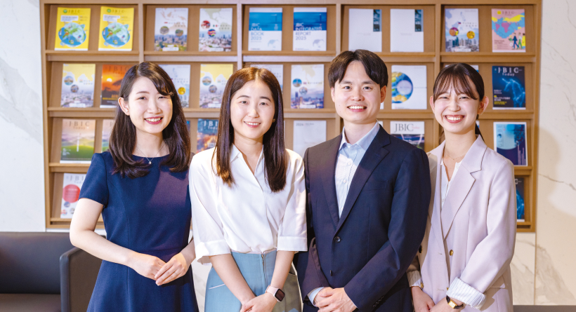 「左から、鈴木 里菜 副主任、日下部 和子 副主任、古島 英輔 係員、井上 葉月 係員。所属：中堅・中小企業ファイナンス室（※当時）」の写真