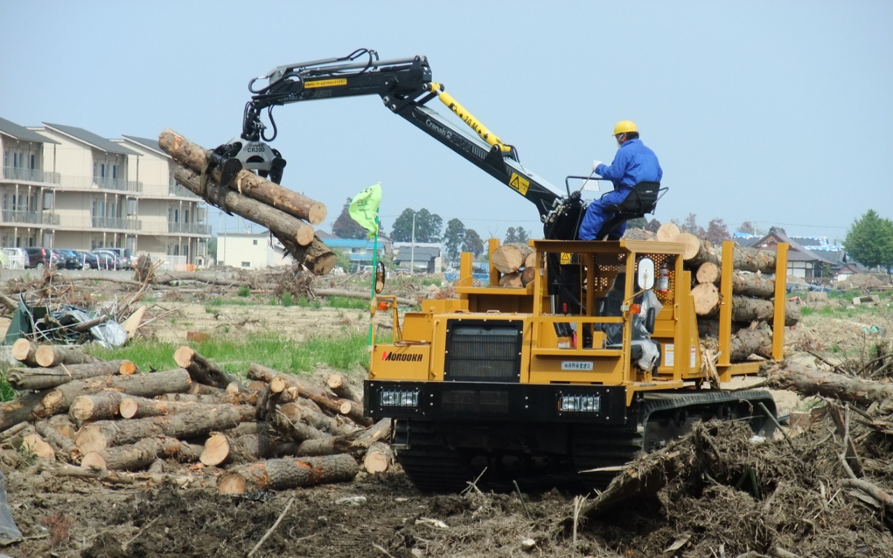 被災地において家屋や流木などの木材がれきの処理に活躍する諸岡の林業機の画像